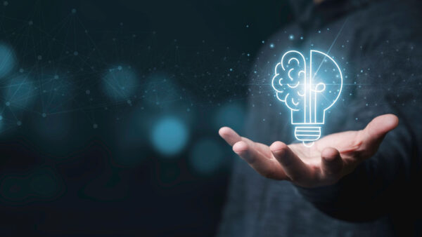 man holding light bulb with half brainwave and half light globe