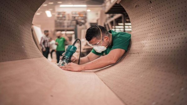 a man grinding the edge of a metal tube