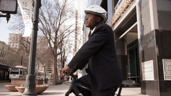 Man cycling to work stops at pedestrian