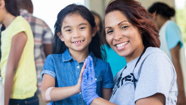 Female health professional with little girl at health fair
