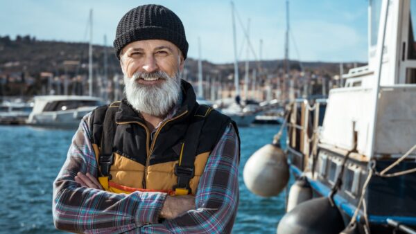 Portrait of senior fisherman in front of the sea