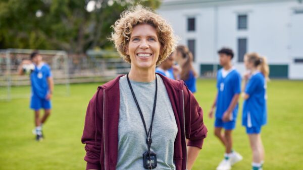Confident female sports coach smiling during lessons