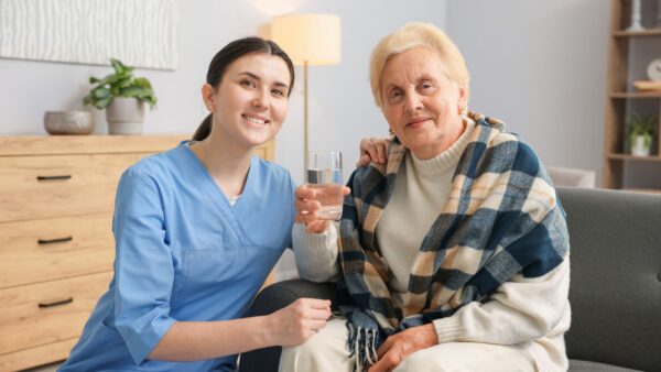 Nurse assisting senior woman indoors