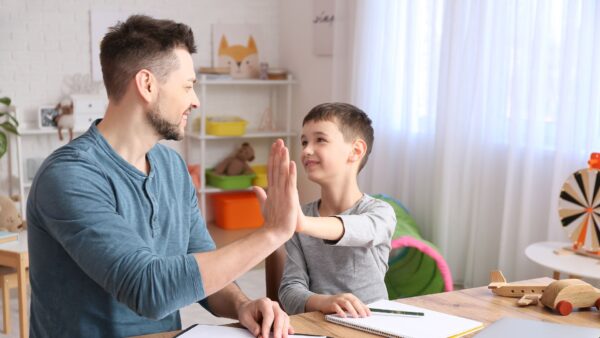 Male psychologist working with little boy in office