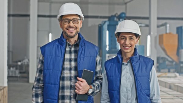 Two industrial engineers smiling to the camera