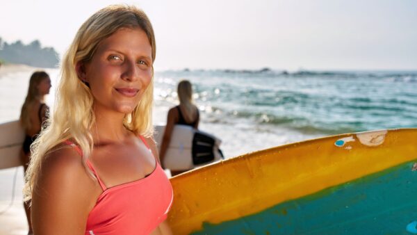 Female surfer instructor at the beach with peers