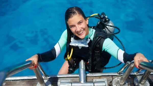 Female scuba diver climbing the boat ladder