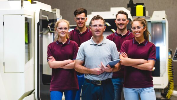 Happy apprentices in manufacturing plant