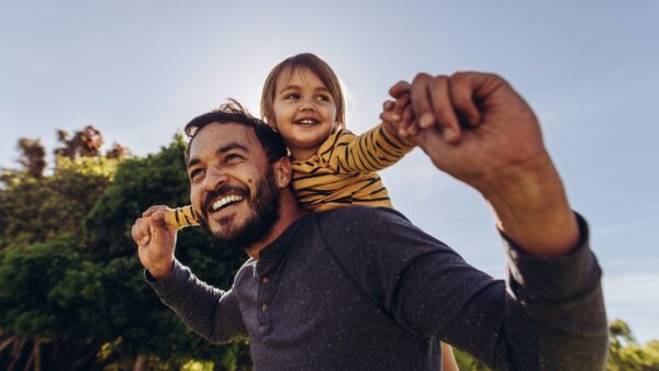 Smiling man playing with his kid outdoors